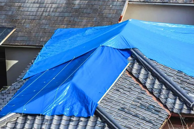 How do you secure a tarp on a roof in high winds